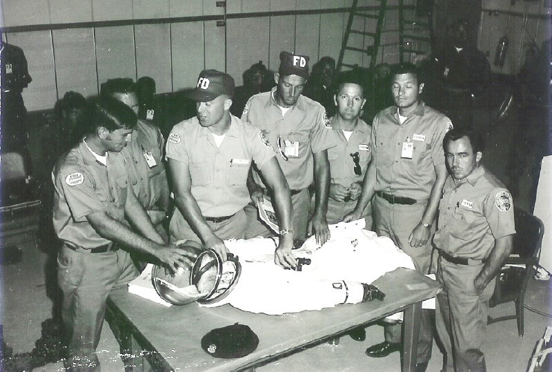 Astronaut Rescueman Bill Killen explaining the procedures for removal of 
helmet and oxygen lines 
